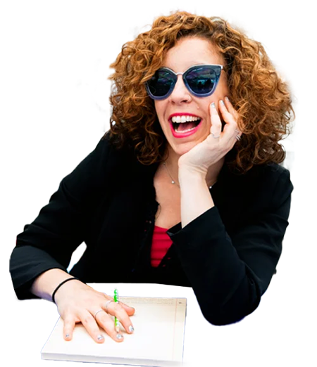 Image of jill laughing and wearing sunglasses while sitting at a desk with pen and paper