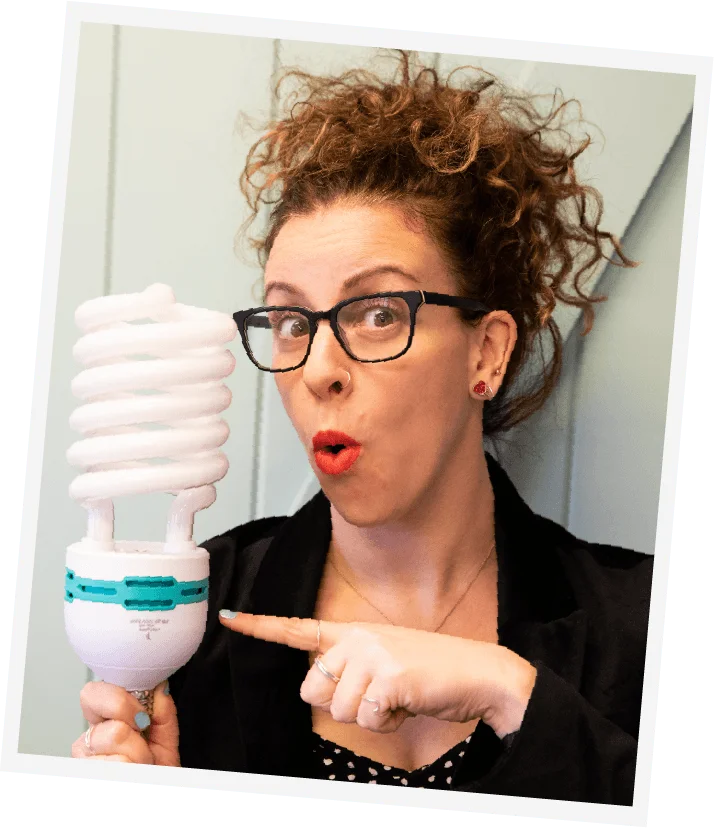 Photo of Jill holding a comically large light bulb with a surprised look on her face.