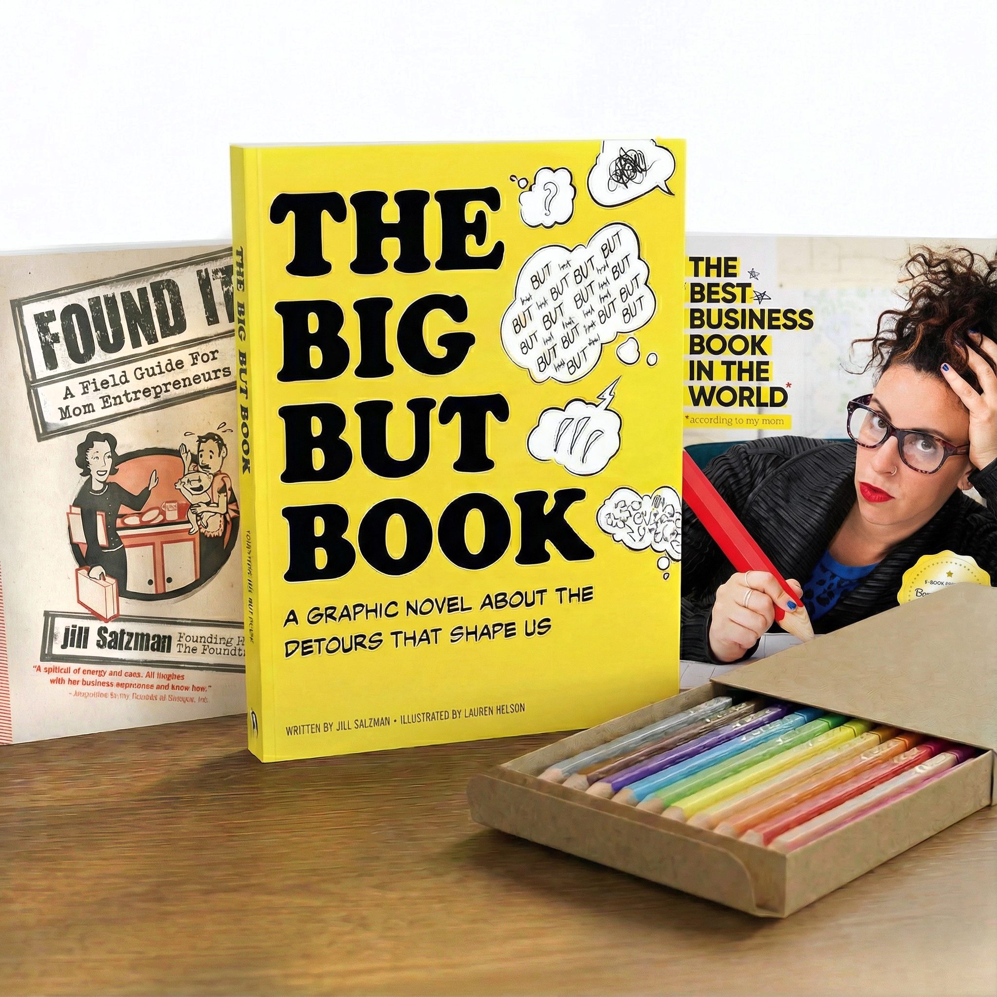Jill Salzman's three books (Found It: A field guide for mom entrepreneurs; The Big But Book; The Best Business Book in the World) lined up on a table next to a pack of colored pencils.